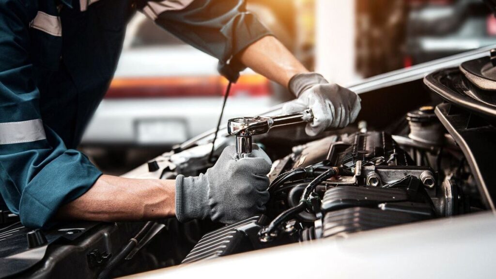 Technician working on an engine with a ratchet
